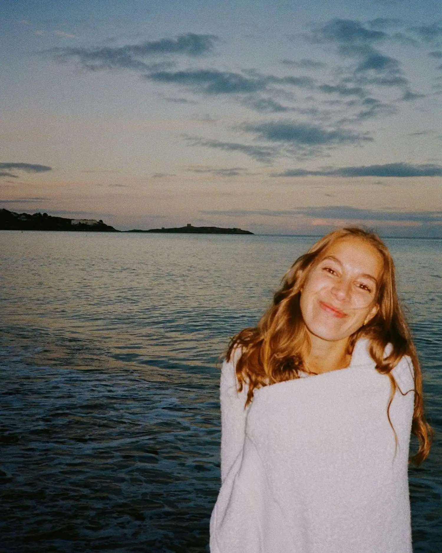 a woman wrapped in a towel on the beach